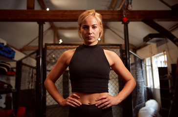 Fototapeta na wymiar Portrait Of Female Mixed Martial Arts Fighter Training In Gym