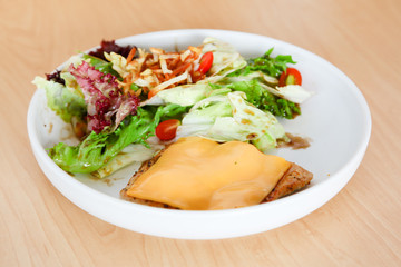 Grilled chicken steak with melted cheese and mixed salad