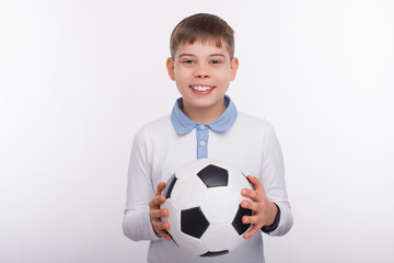 Portrait of cheerful young boy holding soccer ball over white background - Powered by Adobe