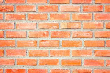 Old Orange brick wall concrete or stone texture background, wallpaper limestone abstract to flooring and homework/Brickwork or stonework clean grid uneven interior rock old. Copy space.