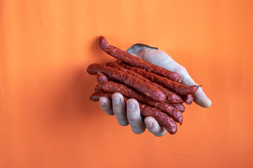 Male hand holds smoked sausages.