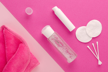 make up remove products, micellar water, face cleaning cloth, cleansing milk and cotton pads on pink background