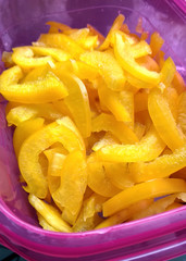 Sliced yellow bell paper in a pink plastic box