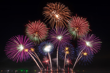 Fototapeta premium real fireworks festival in the sky for celebration at night over the sea at coast side for new year countdown celebration background