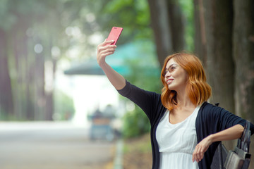 outdoor asian girl sitting and resting in the park. girl makes selfie
