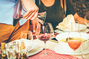 Close-up of man pouring wine during lunch.