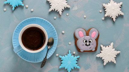 Cup of coffee and gingerbread cookies mouse and snowflakes on a light blue background, Top view, horizontal orientation