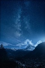 The town of Zermatt and Matterhorn mountain under an epic milky way. Composite image.