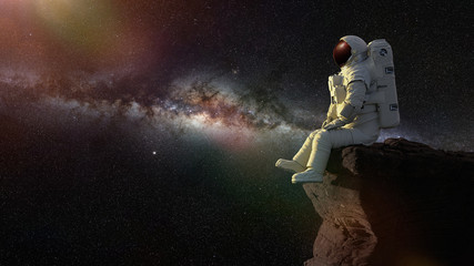astronaut sitting on a cliff enjoying the view over an another world  © dottedyeti