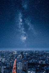 A city at night with an epic milky way on the sky