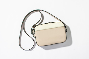 Women's fashion bag with a long handle on a white background. Natural light, modern trend, minimalism. Flat lay, top view