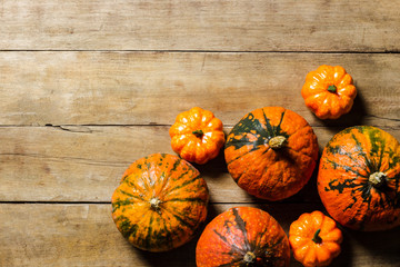 Ripe pumpkins on a wooden background. Harvest concept, autumn, halloween eve. Banner. Flat lay, top view