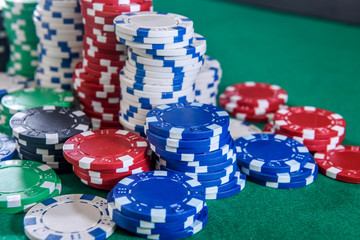 Colorful casino chips on green felt table close up. Gambling concept. Playing poker and other gambling games