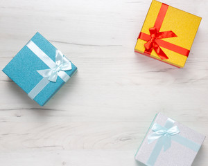 Holiday present boxes with ribbons and bows on wooden background