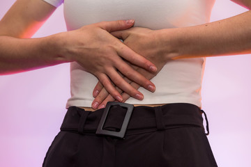 Female hands on belly close up. Pain concept