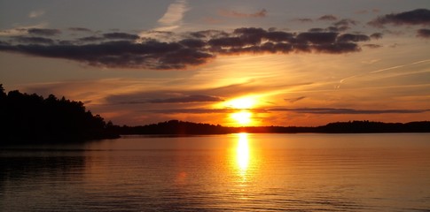Fototapeta na wymiar in the calm lake, the golden sunset is reflected