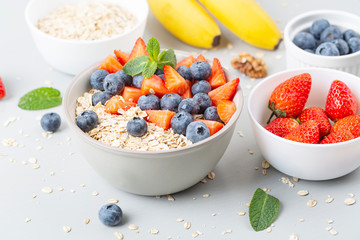 Healthy smoothie bowl with granola, fresh strawberries, blueberries, bananas, yogurt and mint. Healthy food, snack or breakfast. 