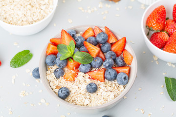 Healthy smoothie bowl with granola, fresh strawberries, blueberries, bananas, yogurt and mint. Healthy food, snack or breakfast. 