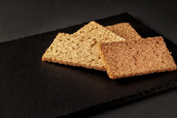 Crispy rye bread on a serving board with rye ears