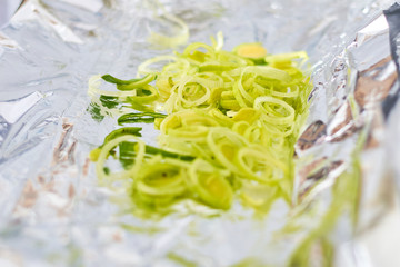Chopped leek on foil. Preparation for baking.