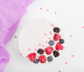 Breakfast smoothie bowl with yogurt, fresh raspberries, blueberries, BlackBerry, coconut flakes and granola. Healthy food. 