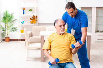 Obraz premium Young male doctor visiting old patient at home