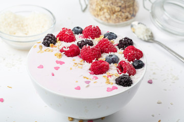 Breakfast smoothie bowl with yogurt, fresh raspberries, blueberries, BlackBerry, coconut flakes and granola. Healthy food. 