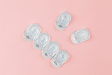 Contact lens packages a pink background. Stack of healthcare disposable contact lens. Flat lay...