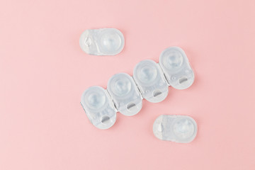 Contact lens packages a pink background. Stack of healthcare disposable contact lens. Flat lay composition