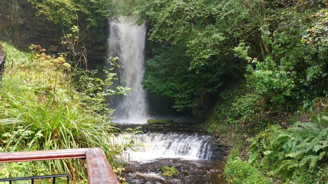 Glencar waterfall nested in small gorge in Ireland and late in Autumn filled with water after rain.