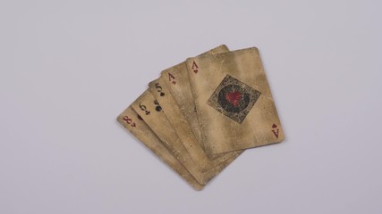 Poker hand showing a one pair of red aces with an eight, six and five, which is tidied away by a caucasian hand