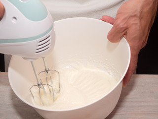 Beating yogurt and sugar with mixer. Making Yogurt Cake.