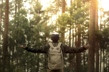 Obraz premium Traveler man with backpack standing near tropical jungle at sunny day