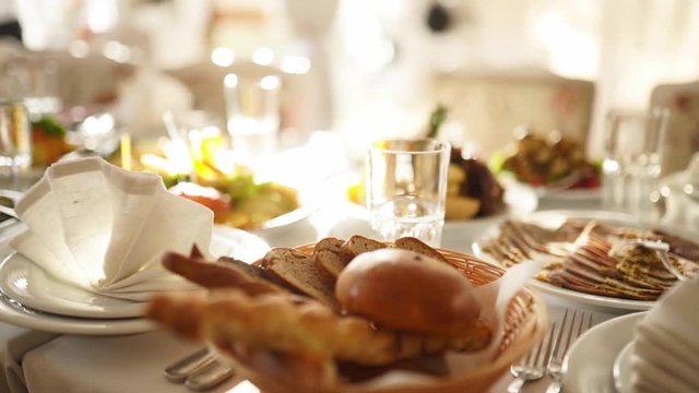 Beautifully served banquet table with different food snacks and appetizers in the sun on corporate christmas birthday party event or wedding celebration. Decorated catering in white interior.