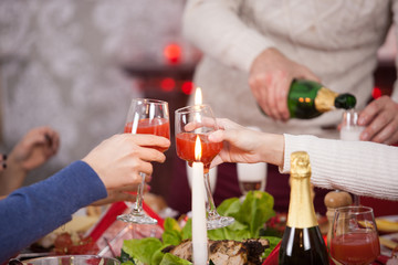 Close up of two young woman clinking glasses at christmas feast