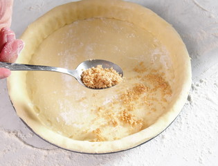 Spoon filling mixture into pastry case. Making Treacle Pie Series.
