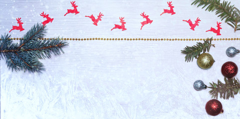 Christmas background with reindeer, baubles, twigs and a gold chain.