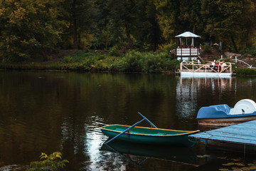 Green rowing boat on a lake in a city park