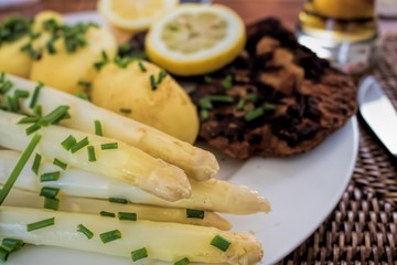 teller mit frischen spargeln und kotelett