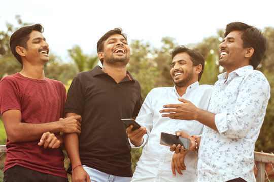 Multi Racial Friends Having Fun Outdoor Laughing By Watching Into The Mobile - Concept Of Diversity, Friendship And Sharing Positive Vibes.