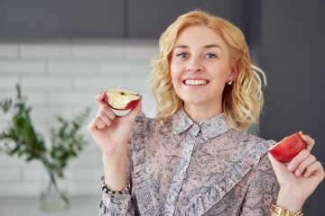 vegan woman holding 2 halves of a sliced apple