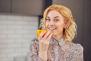 young woman eating an orange