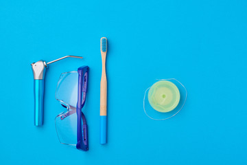 Fototapeta na wymiar Dentist tools over blue background top view copy space flat lay. Tooth care, dental hygiene and health concept.