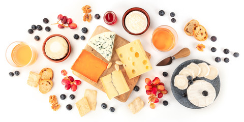 Cheese board panorama with wine and fruit, a flat lay, shot from the top on a white background