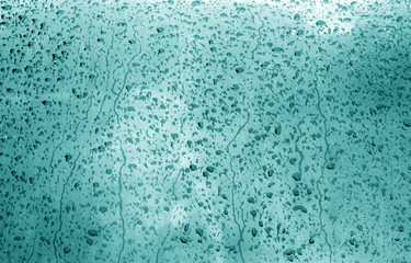 Water on blurred window in cyan tone.