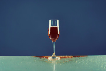 Red wine in a glass on blue background
