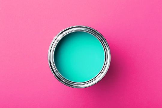 Can of turquoise paint on pink.