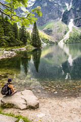 Woman tourist with backpack at Morskie Oko lake near Zakopane, Tatra Mountains, Poland