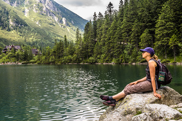 Woman hiker with backpack at Morskie Oko lake near Zakopane, Tatra Mountains, Poland