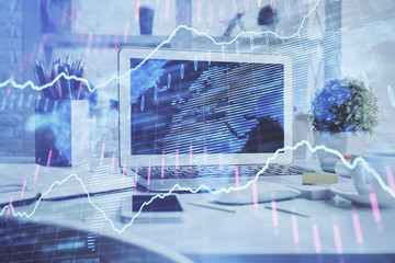 Stock market graph on background with desk and personal computer. Multi exposure. Concept of financial analysis.